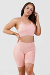 Girl posing wearing pink calypso seamless sport bra front