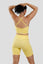 Girl posing wearing calypso seamless set in yellow back