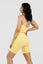 Girl posing hand on hip wearing calypso seamless set in yellow back