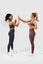Girls wearing charcoal and mauve purple invictus seamless sets clapping hands