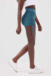 Close up girl wearing blue luna scrunch bum shorts front