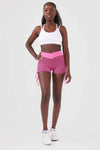 Close up girl wearing pink luna scrunch bum shorts front