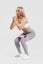girl wearing grey adapt scrunch bum leggings, white crop top with pink resistance band around thighs