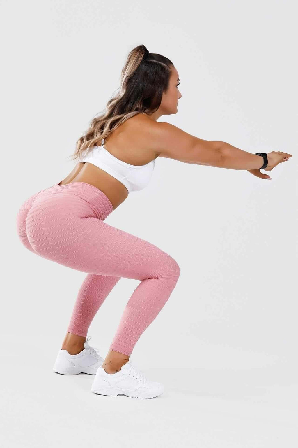 Full shot of girl holding squat wearing pink adapt scrunch bum leggings
