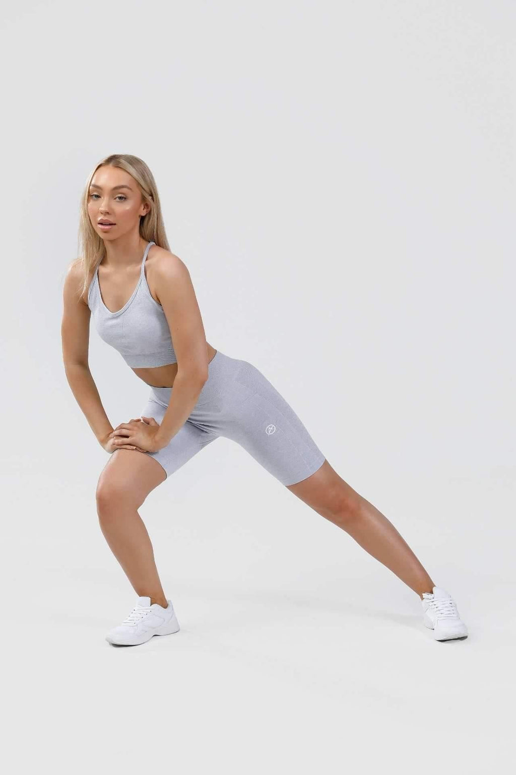 Girl lunging to the side wearing calypso seamless set in blue marl