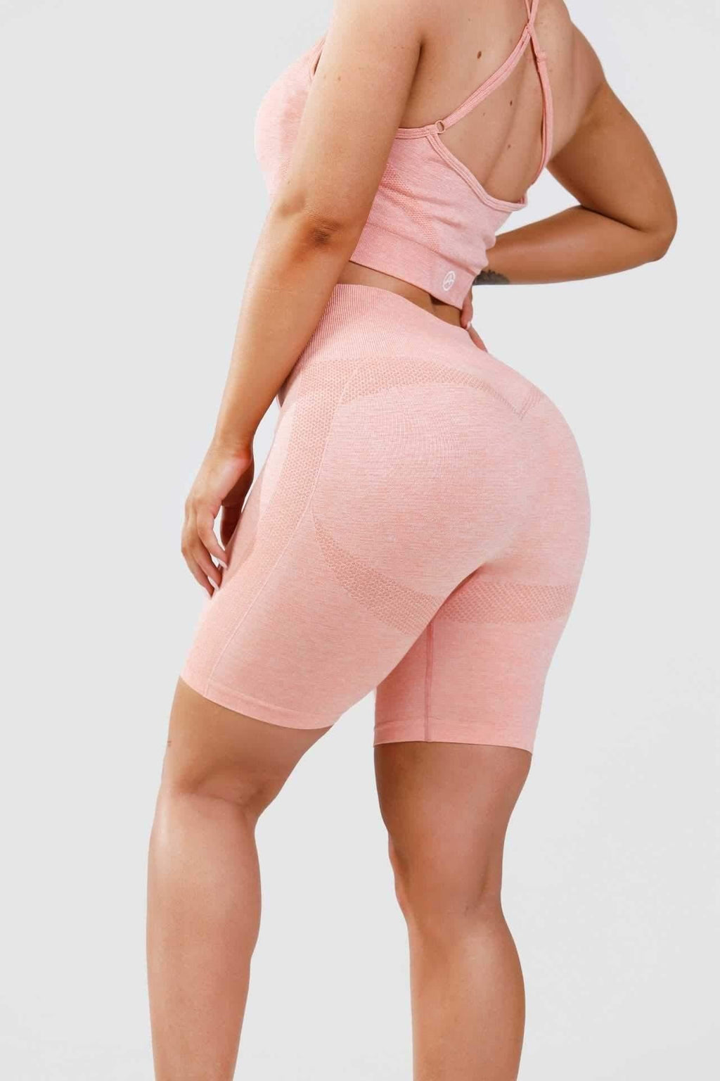 Girl posing wearing calypso seamless set in pink marl, behind