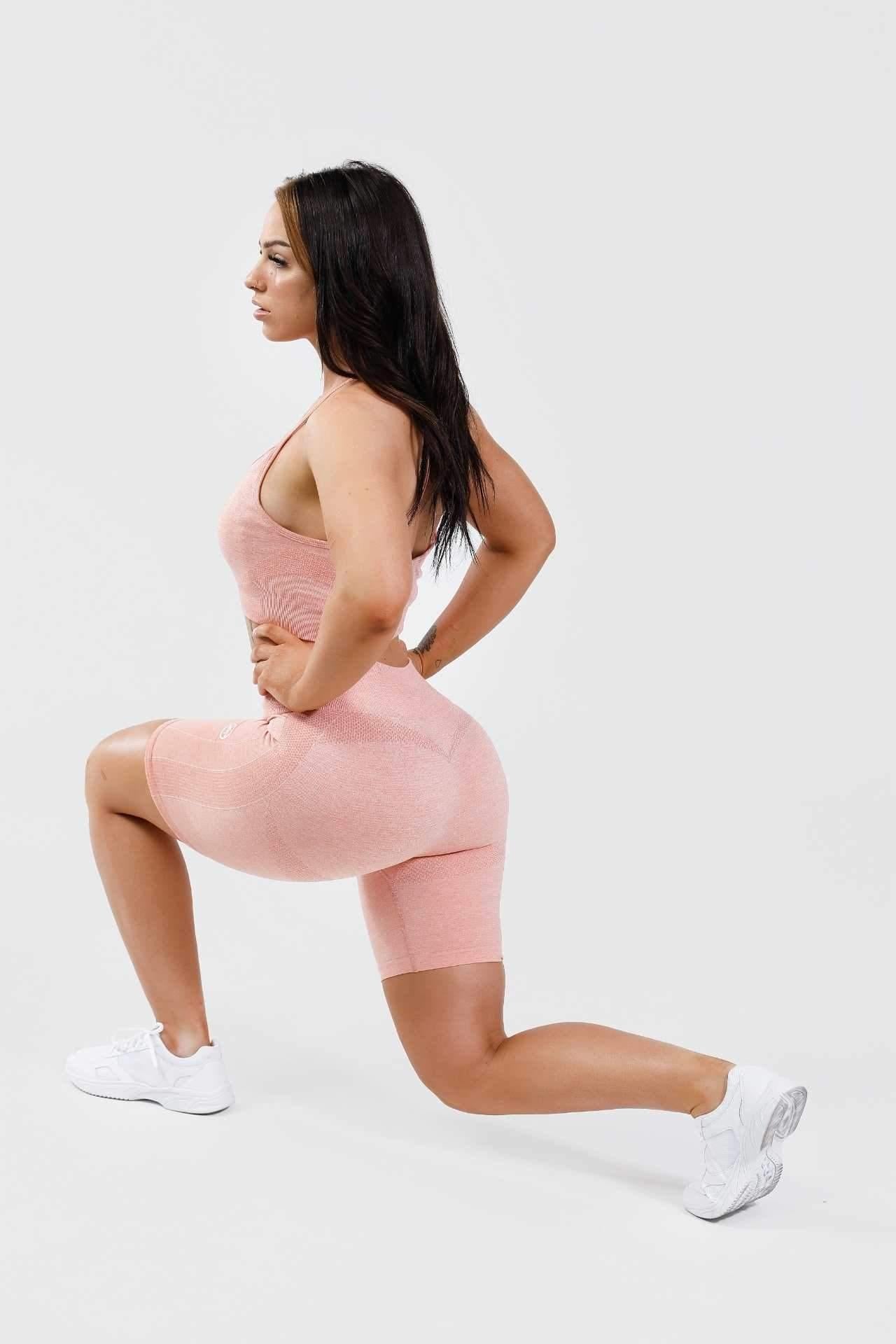 Girl holding lunge, hands on hips, wearing calypso seamless set in pink marl