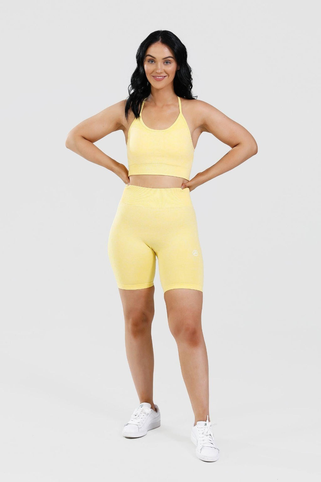 Girl posing hand on hips wearing yellow calypso seamless set