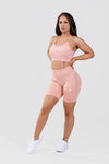 Girl posing wearing pink calypso seamless sport bra front