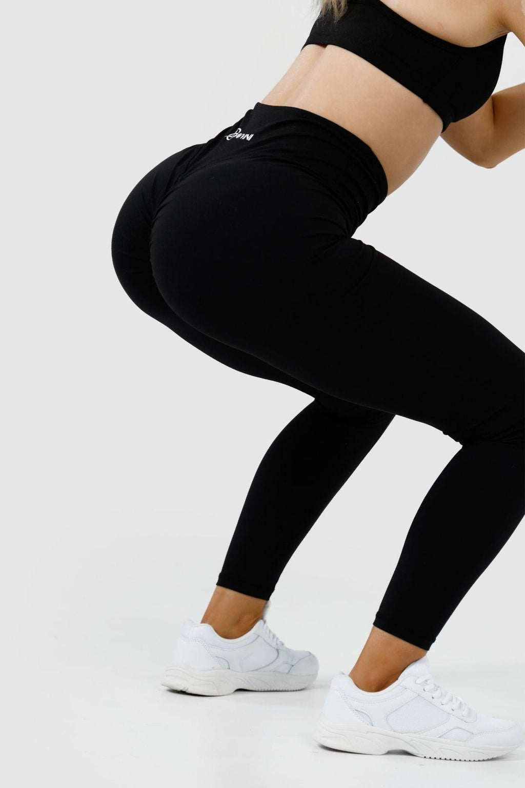 Close up girl squatting wearing black intrigue scrunch bum leggings