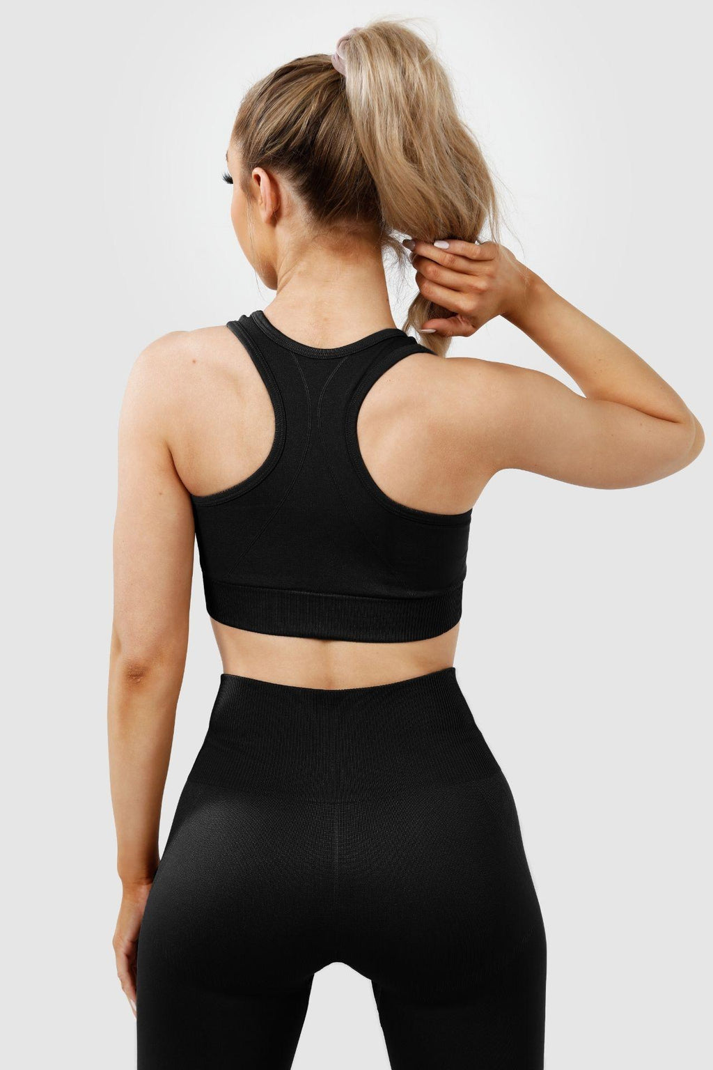 Girl wearing invictus seamless set in black, back