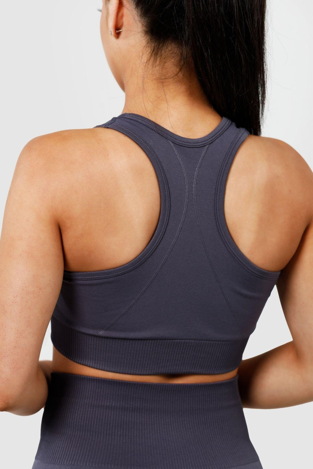 Close up girl wearing invictus seamless crop charcoal, back