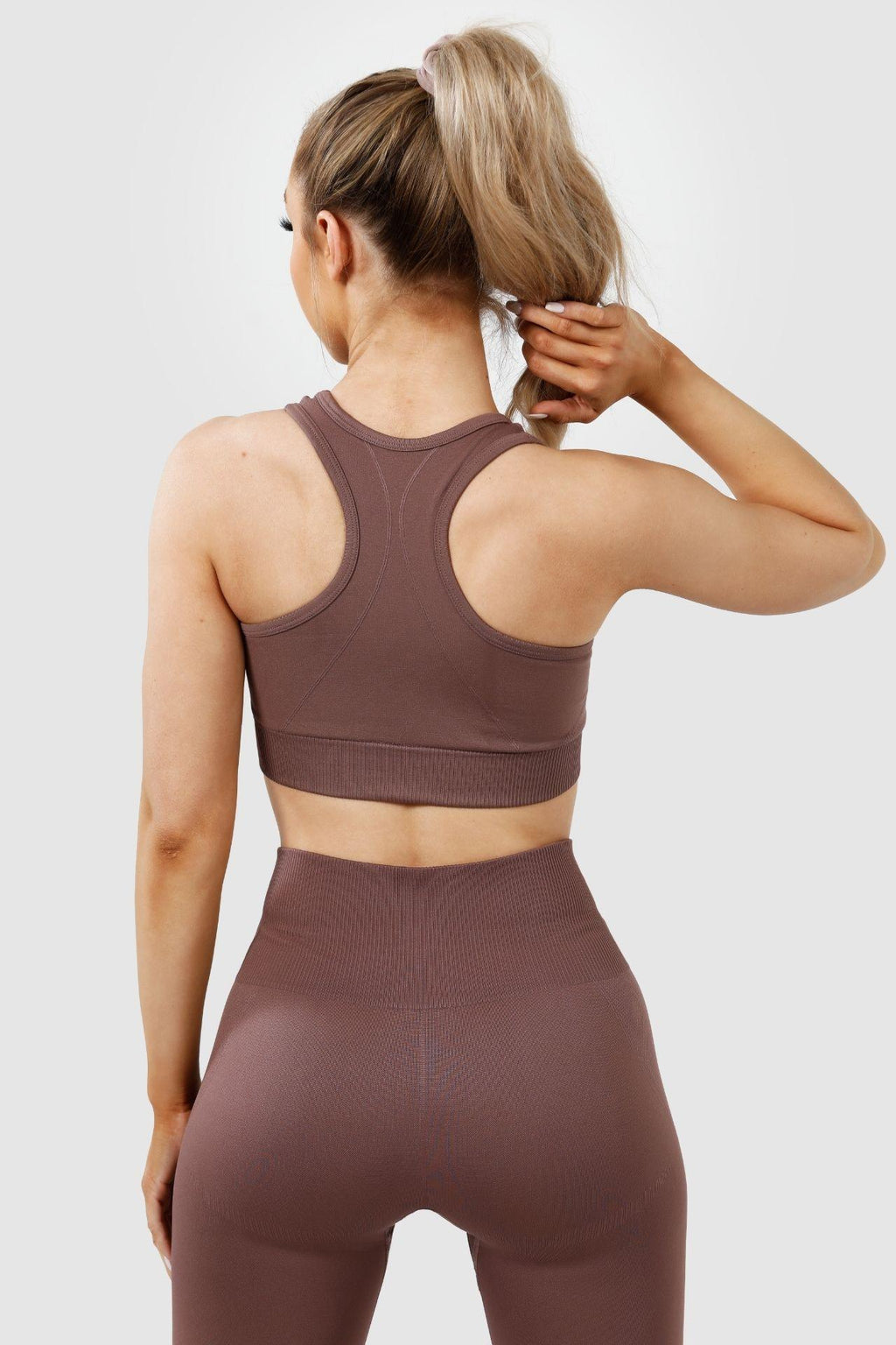 Girl wearing invictus seamless set in mauve purple, back