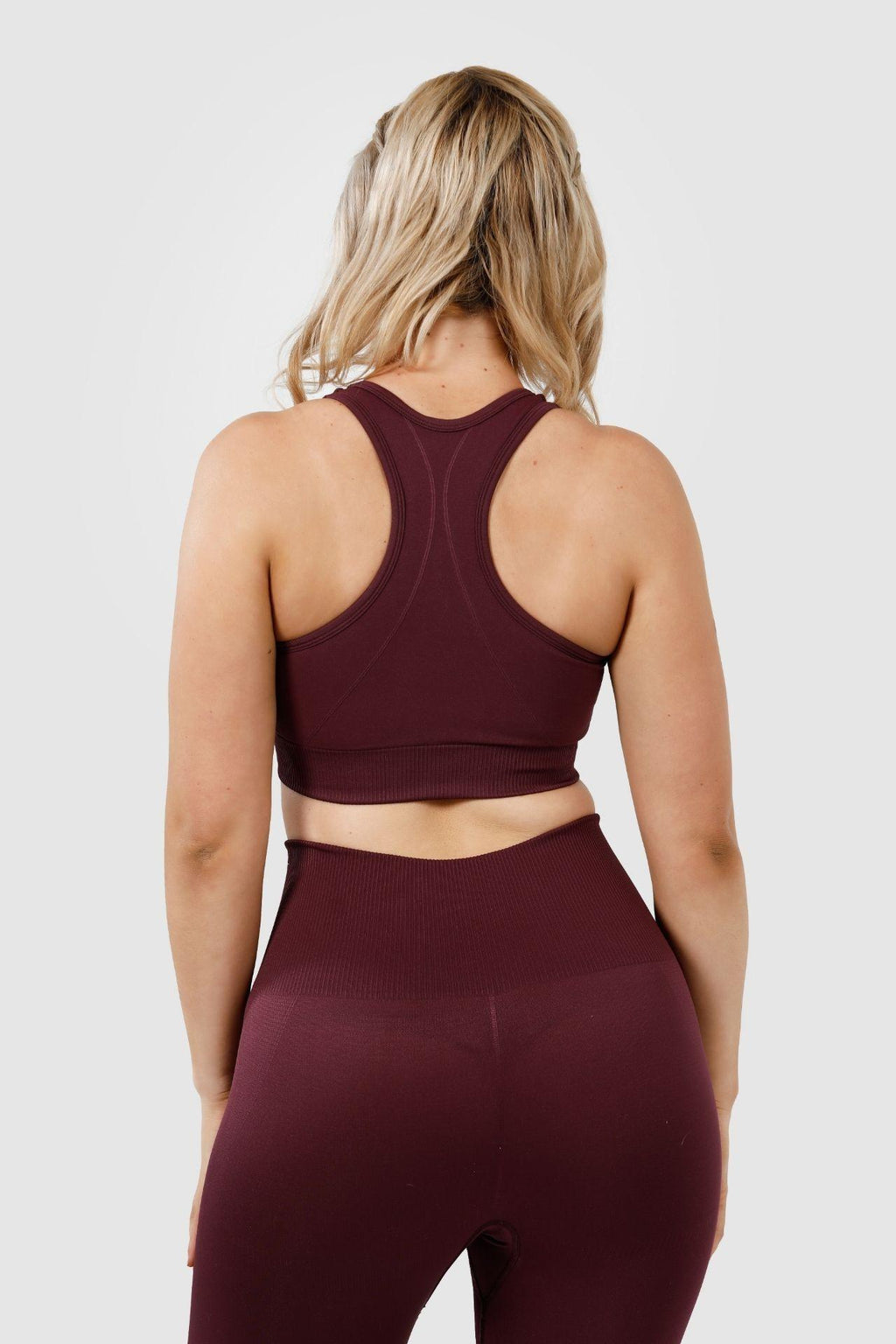 Girl wearing invictus seamless set plum purple back 