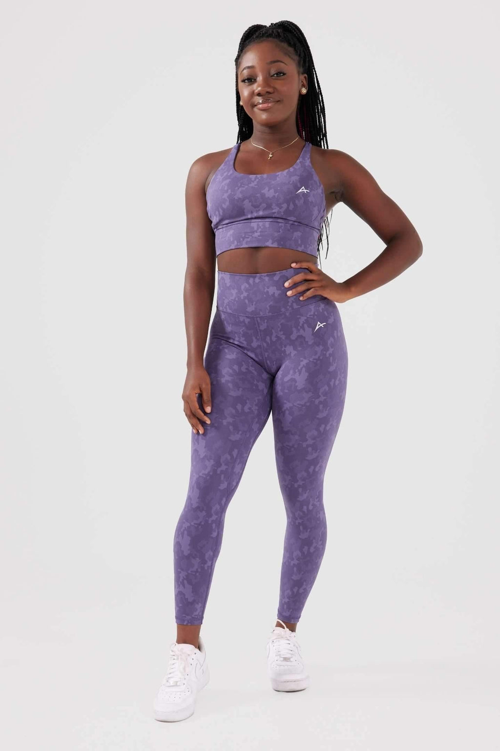Girl posing hand on hip wearing legacy scrunch bum set in purple front