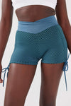 Close up girl wearing blue luna scrunch bum shorts front