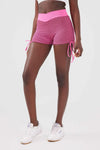Close up girl wearing pink luna scrunch bum shorts front