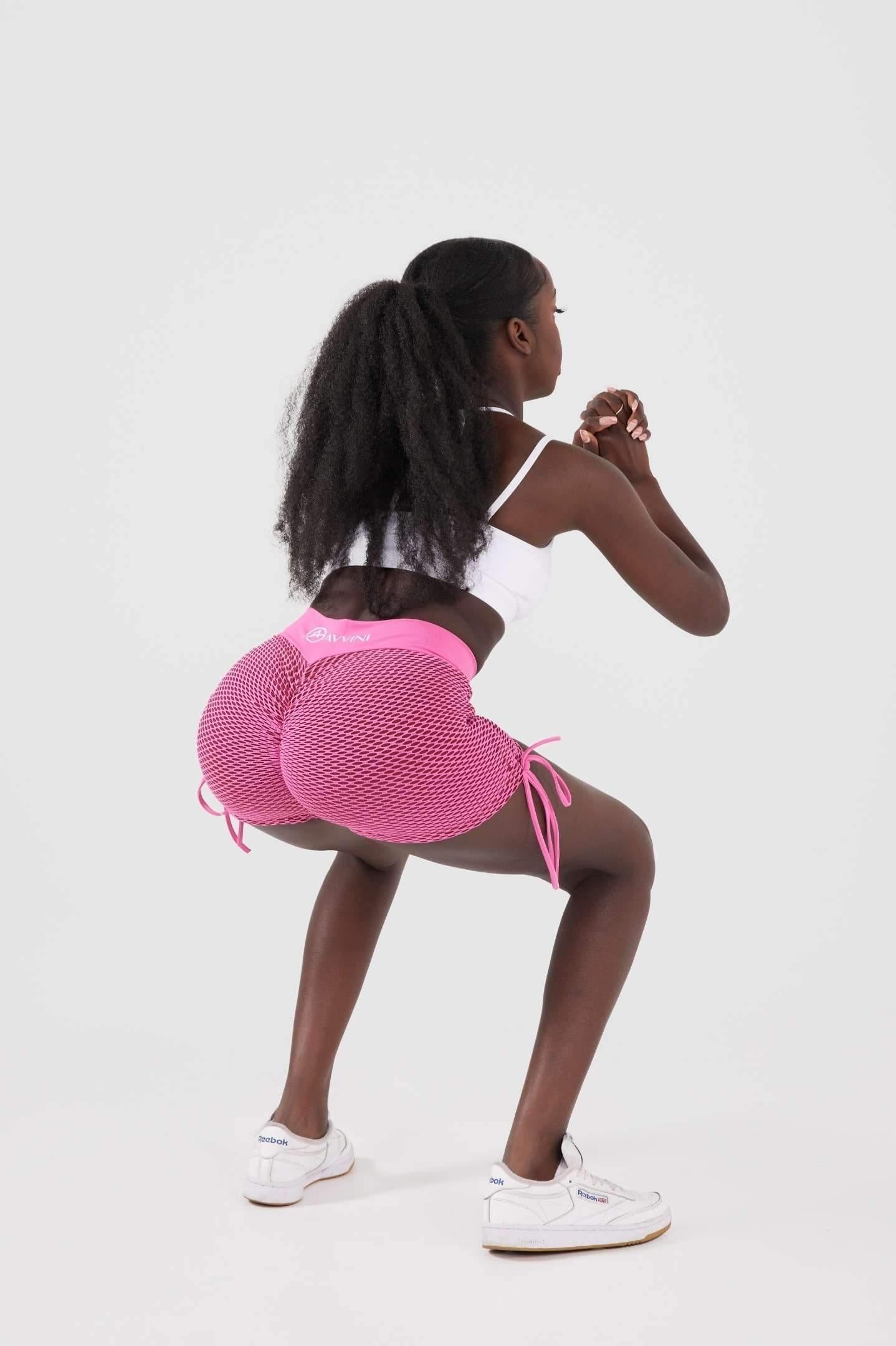 girl squatting wearing pink luna scrunch bum shorts