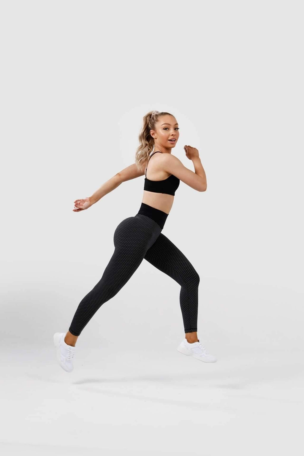Girl leaping wearing black luna scrunch bum leggings 