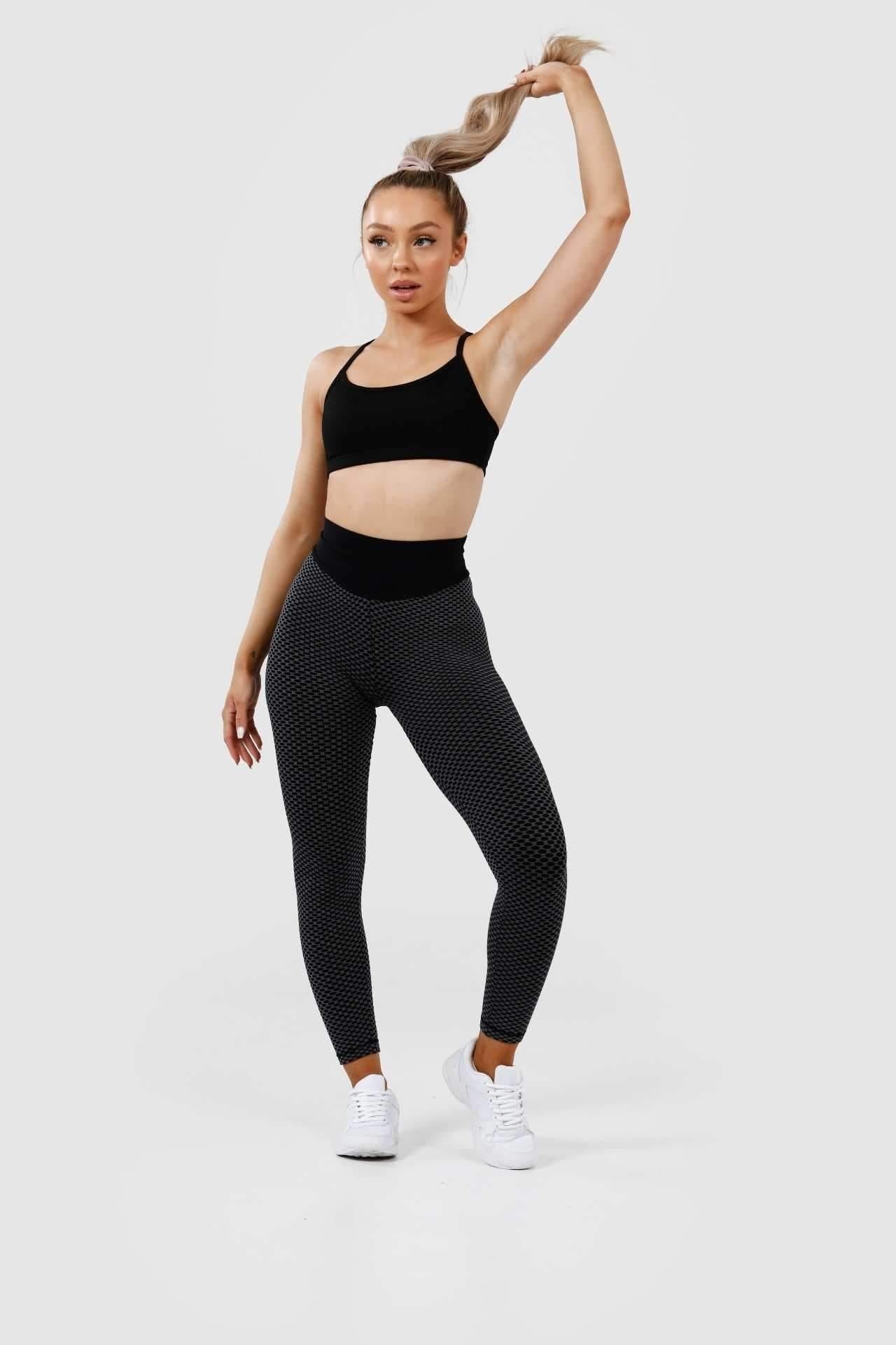 Girl posing holding hair wearing black luna scrunch bum leggings front