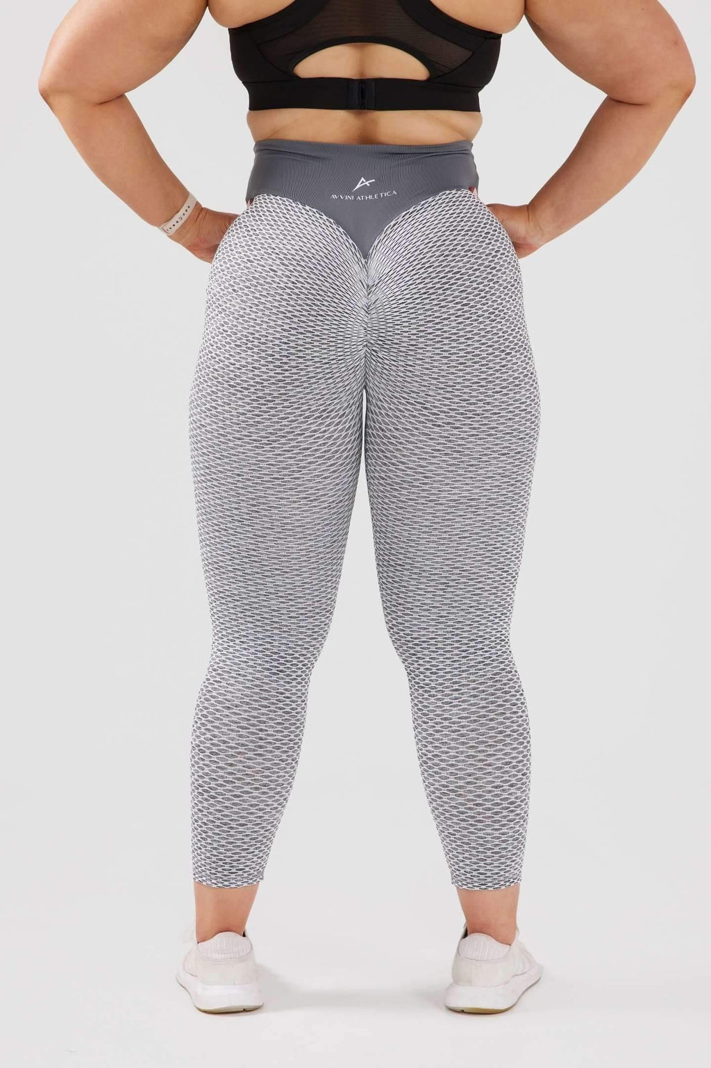 Girl posing hands on hips wearing large grey luna scrunch bum leggings back