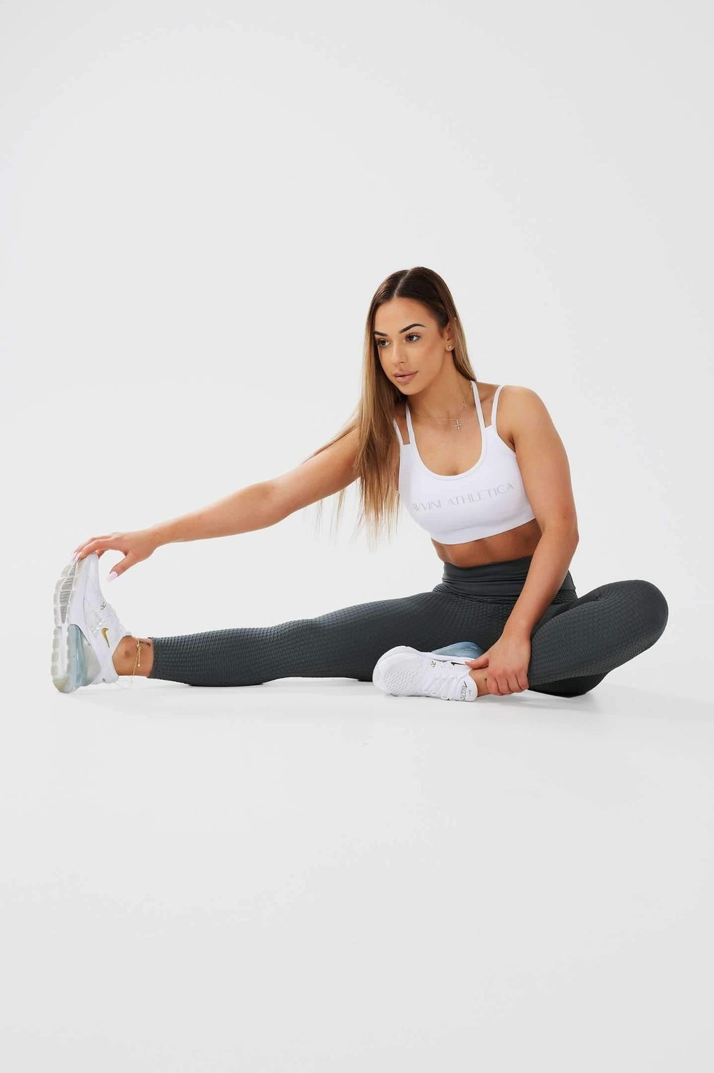 Girl stretching on floor wearing khaki luna x seamless scrunch bum leggings and white classic crop