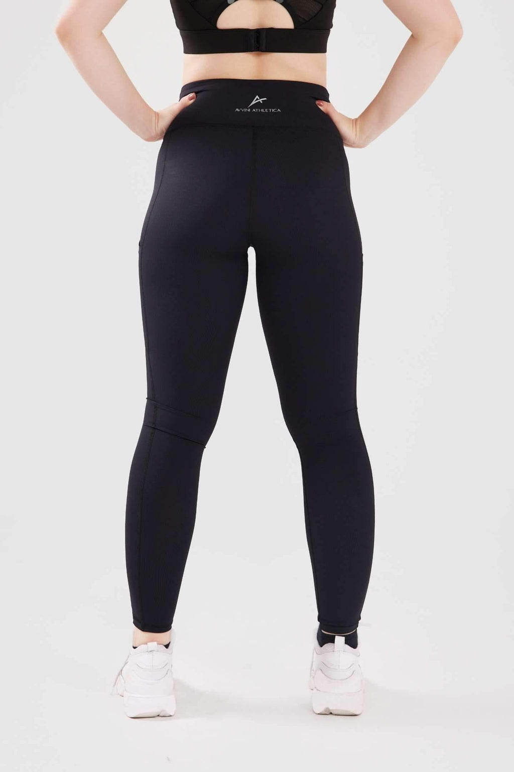 Close up girl posing hands on hips wearing black luxe pocket leggings back 