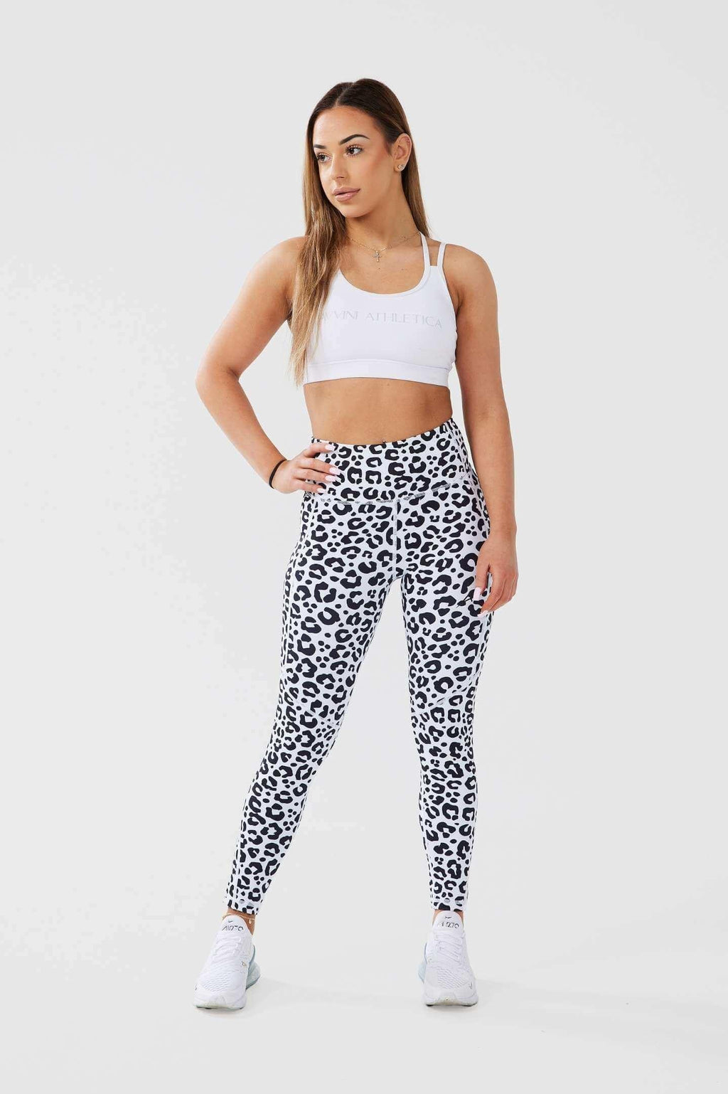 Girl posing hand on hip wearing leopard luxe scrunch bum leggings, white classic crop front