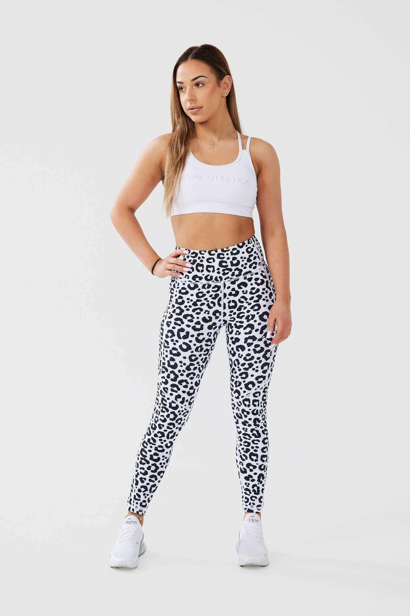 Girl posing hand on hip wearing leopard luxe scrunch bum leggings, white classic crop front