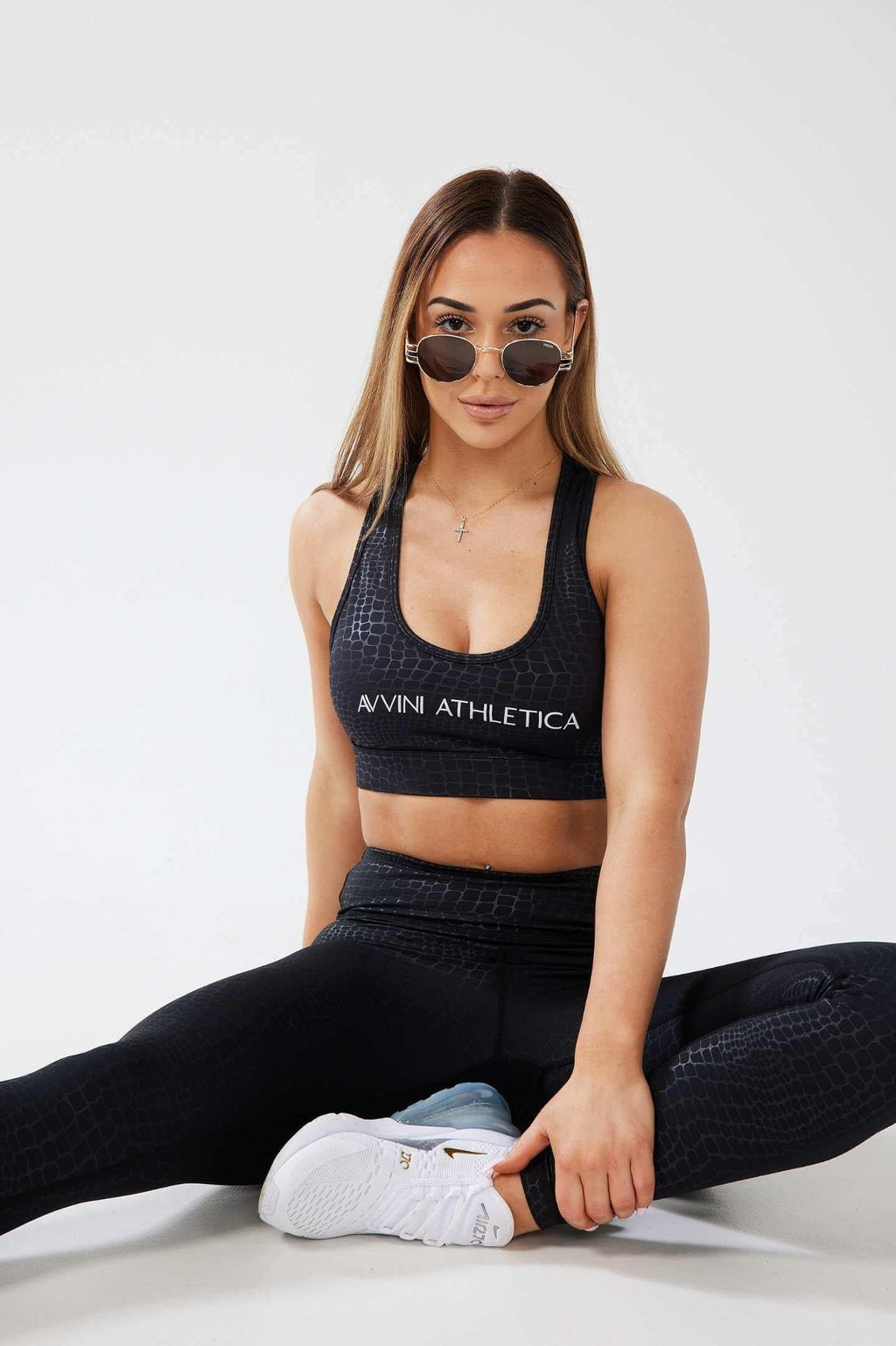 Girl stretching on floor wearing sunglasses wearing luxe snake print set